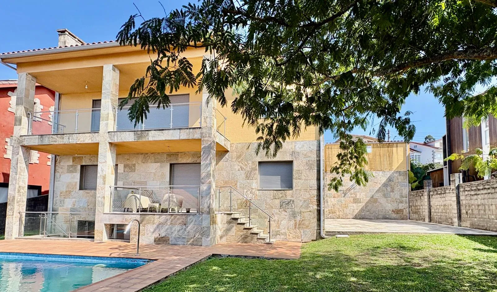 Fachada de la casa con piscina y jardín en Poio